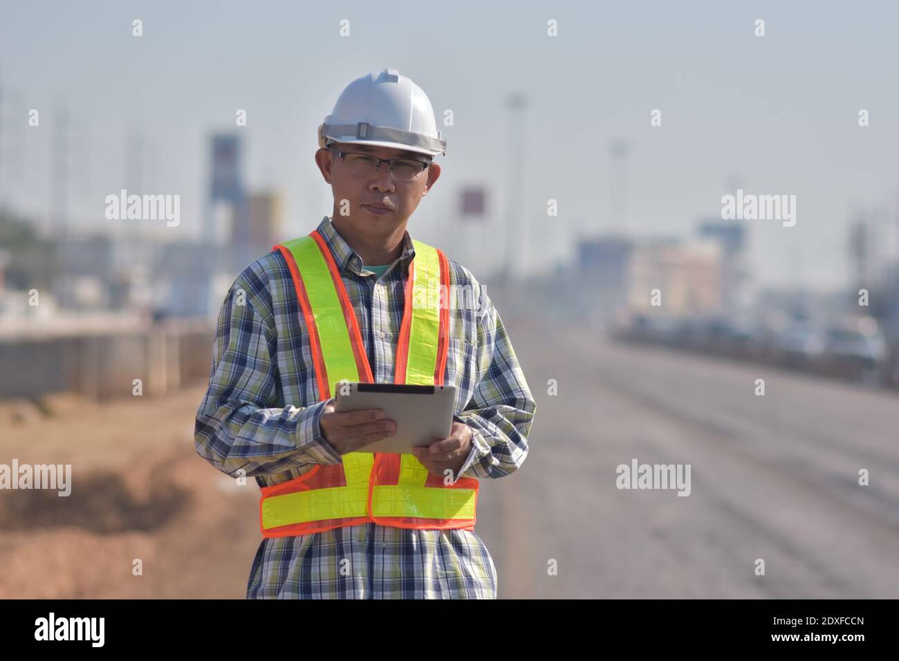 Senior Engineering Worker durch Tablet-Inspektion auf der Baustelle Straßenbau Stockfoto