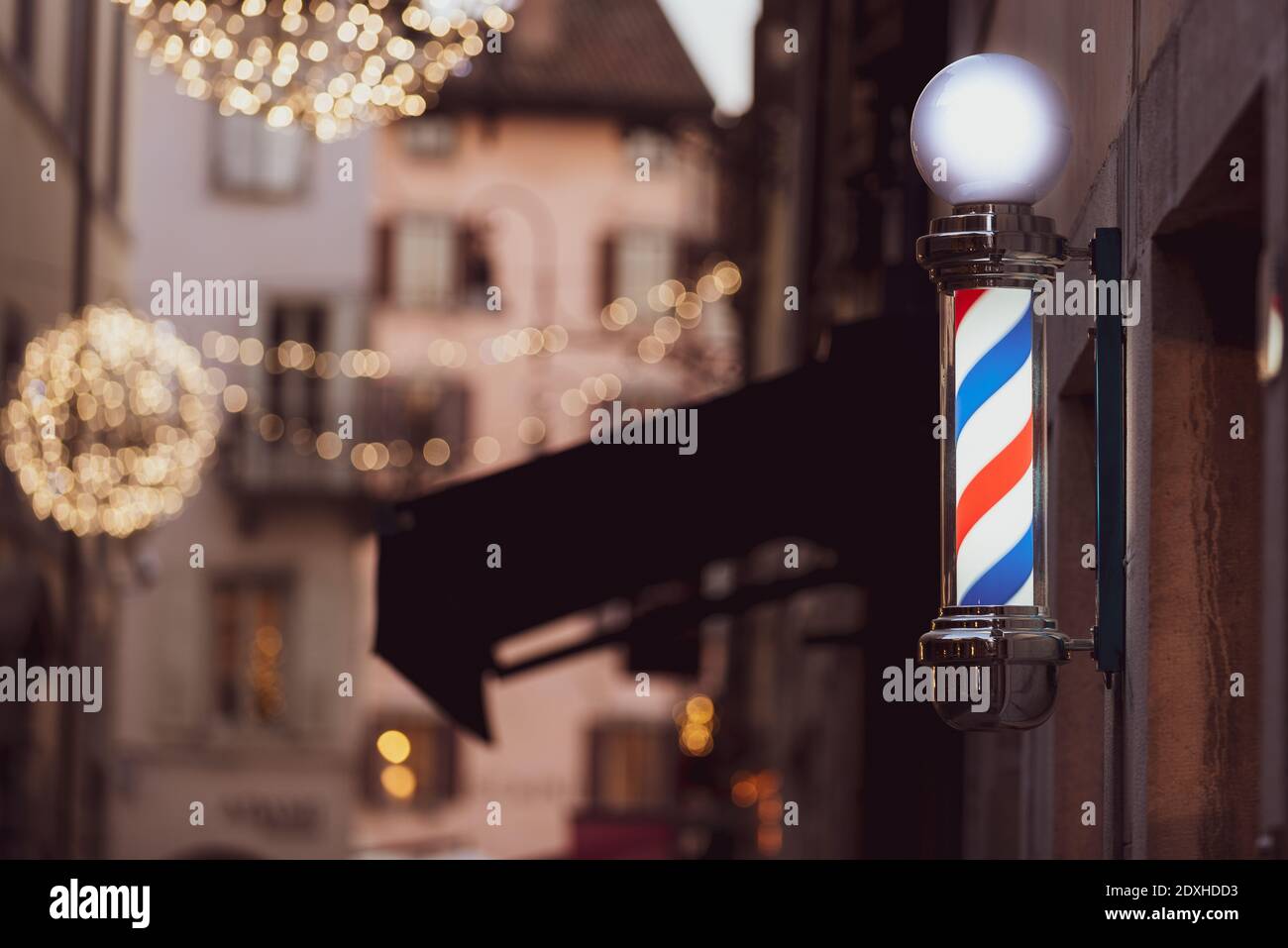 Friseurladen Stange und Weihnachtsbeleuchtung in Udine Stadt, Friaul Julisch Venetien, Italien. Stockfoto