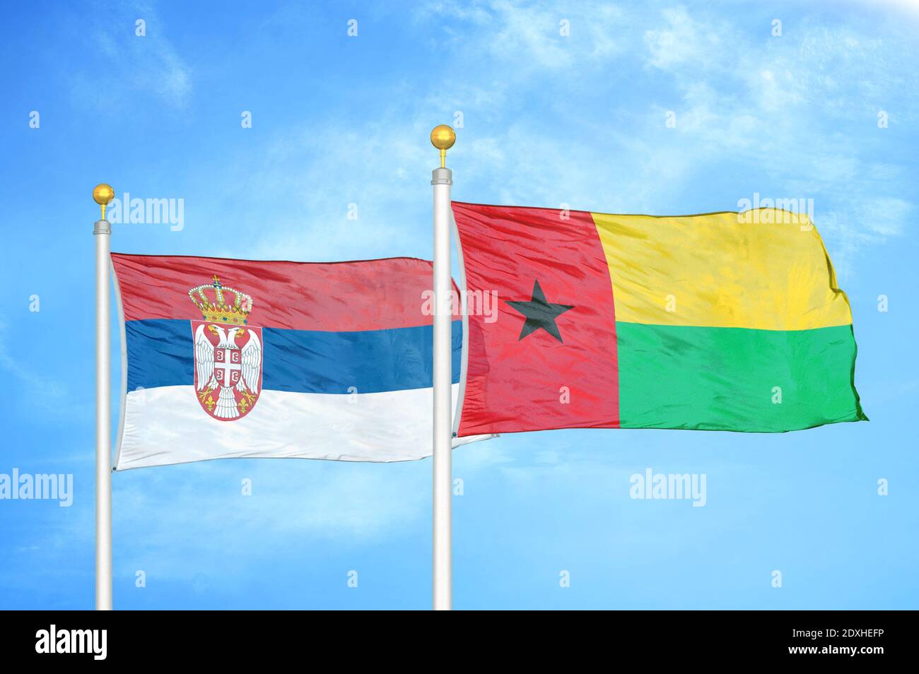 Serbien und Guinea-Bissau zwei Flaggen auf Fahnenmasten und blauer Himmel Stockfoto