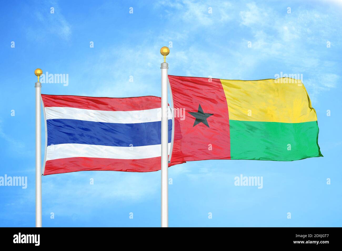 Thailand und Guinea-Bissau zwei Flaggen auf Fahnenmasten und blauer Himmel Stockfoto
