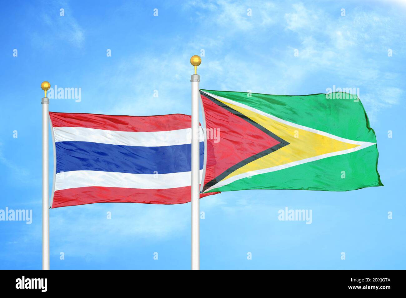 Thailand und Guyana zwei Flaggen auf Fahnenmasten und blauer Himmel Stockfoto