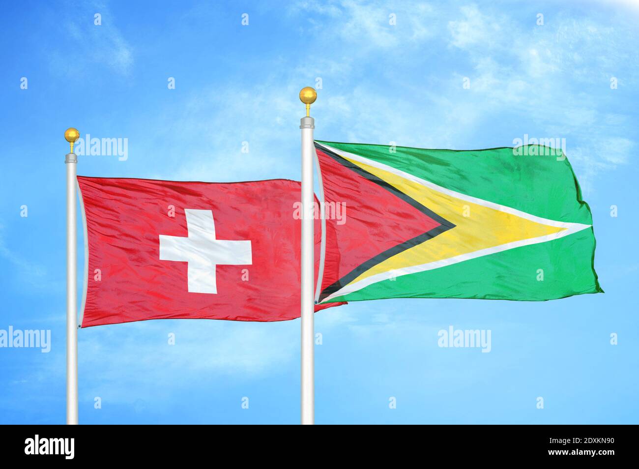 Schweiz und Guyana zwei Flaggen auf Fahnenmasten und blauer Himmel Stockfoto