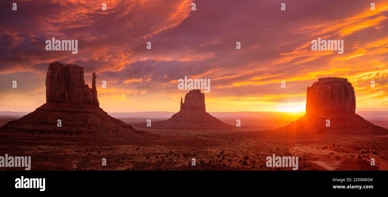 Sonnenaufgang hinter West Mitten Butte, East Mitten Butte und Merrick Butte, The Fäustlinge bei Sonnenaufgang, Monument Valley Navajo Tribal Park, Arizona, USA Stockfoto