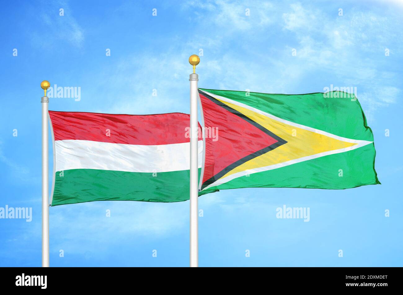 Ungarn und Guyana zwei Flaggen auf Fahnenmasten und blau bewölkt Himmel Stockfoto