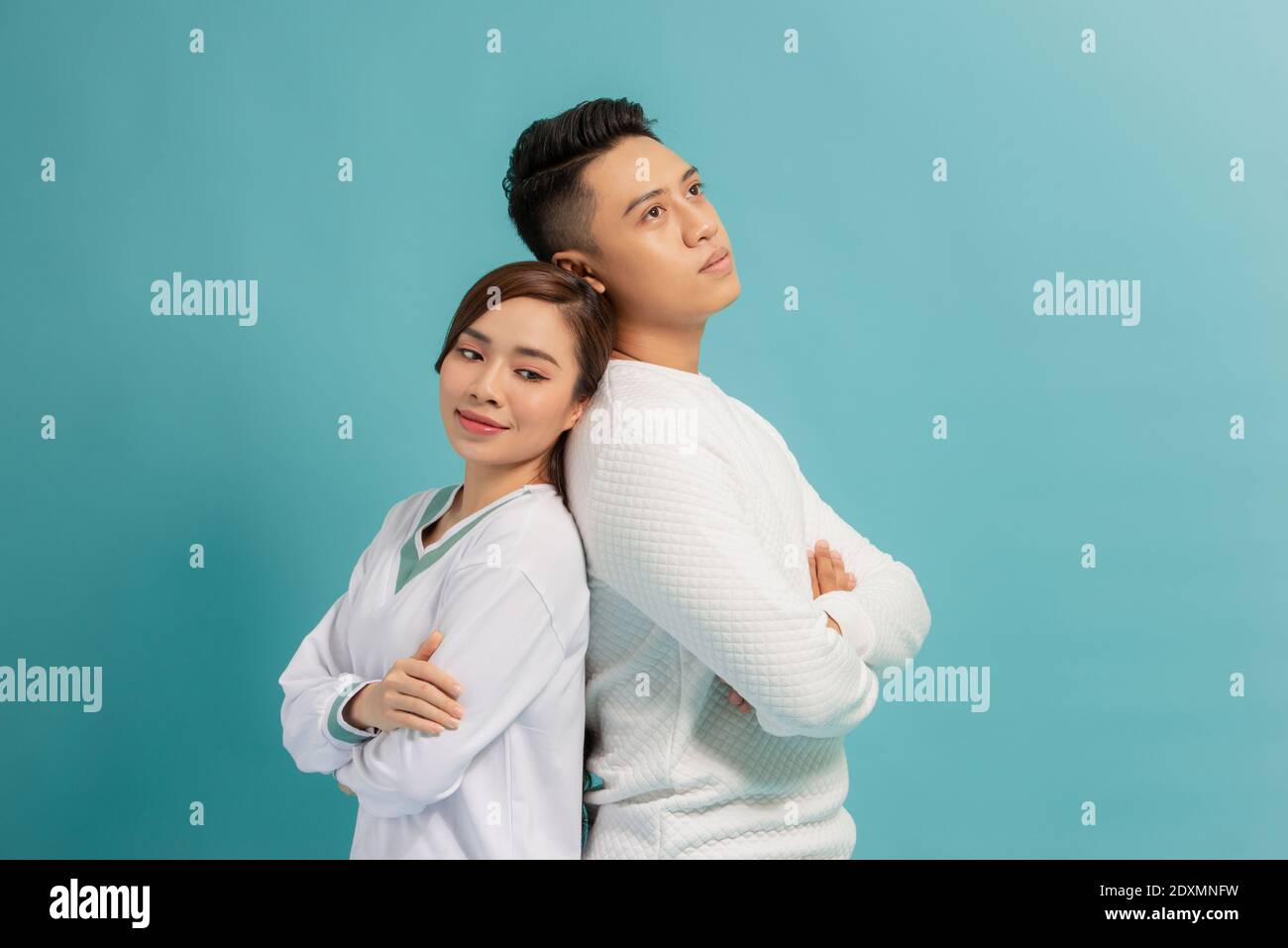 Studio Foto von schönen glücklichen Paar halten die Hände gekreuzt Ihre Truhen und Lachen glücklich stehend über blauen Hintergrund Stockfoto