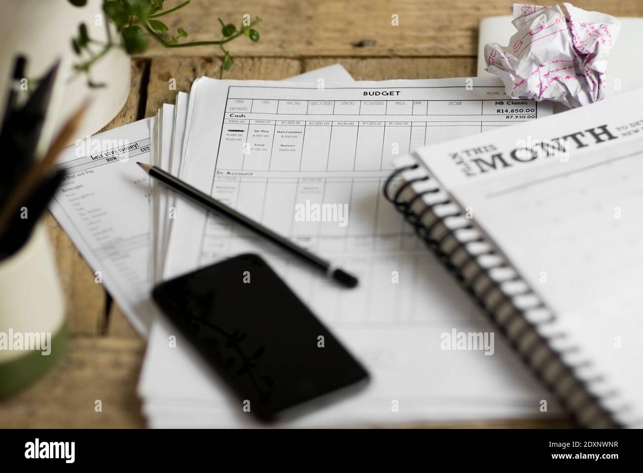 Nahaufnahme eines überladen, unorganisiert und unordentlich Schreibtisch, wo ein Budget wird ausgearbeitet Stockfoto