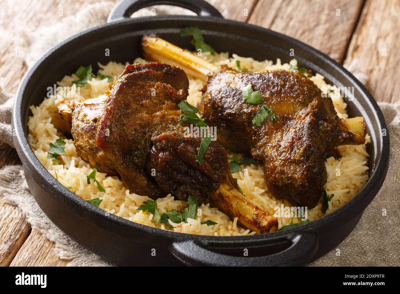 Beliebte jemenitischen gebackenen Lammschenkel serviert mit Basmati-Reis close-up in einer Pfanne auf dem Tisch. Horizontal Stockfoto