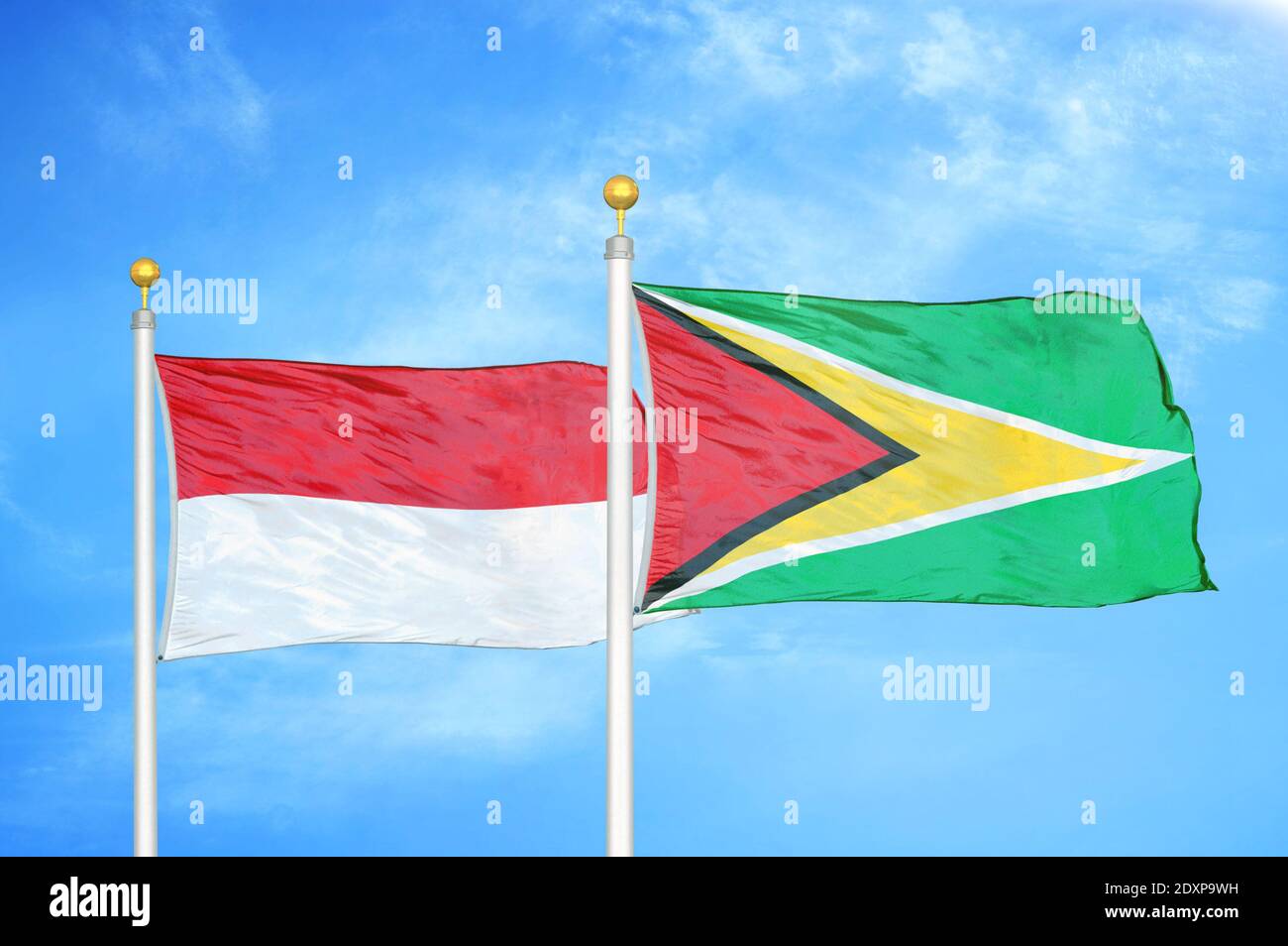 Indonesien und Guyana zwei Flaggen auf Fahnenmasten und blau bewölkt Himmel Stockfoto