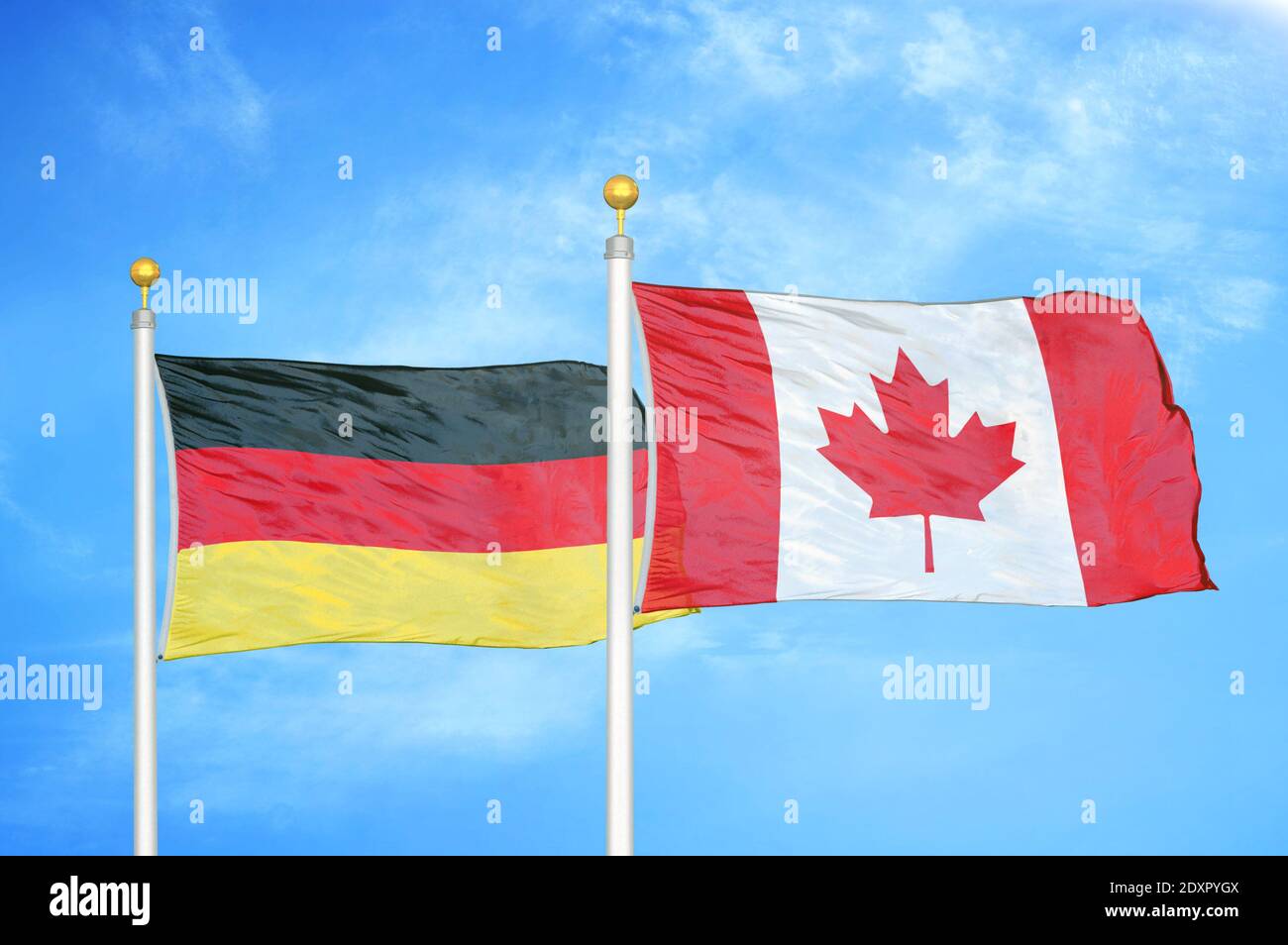 Deutschland und Kanada zwei Flaggen auf Fahnenmasten und blau bewölkt Himmel Stockfoto