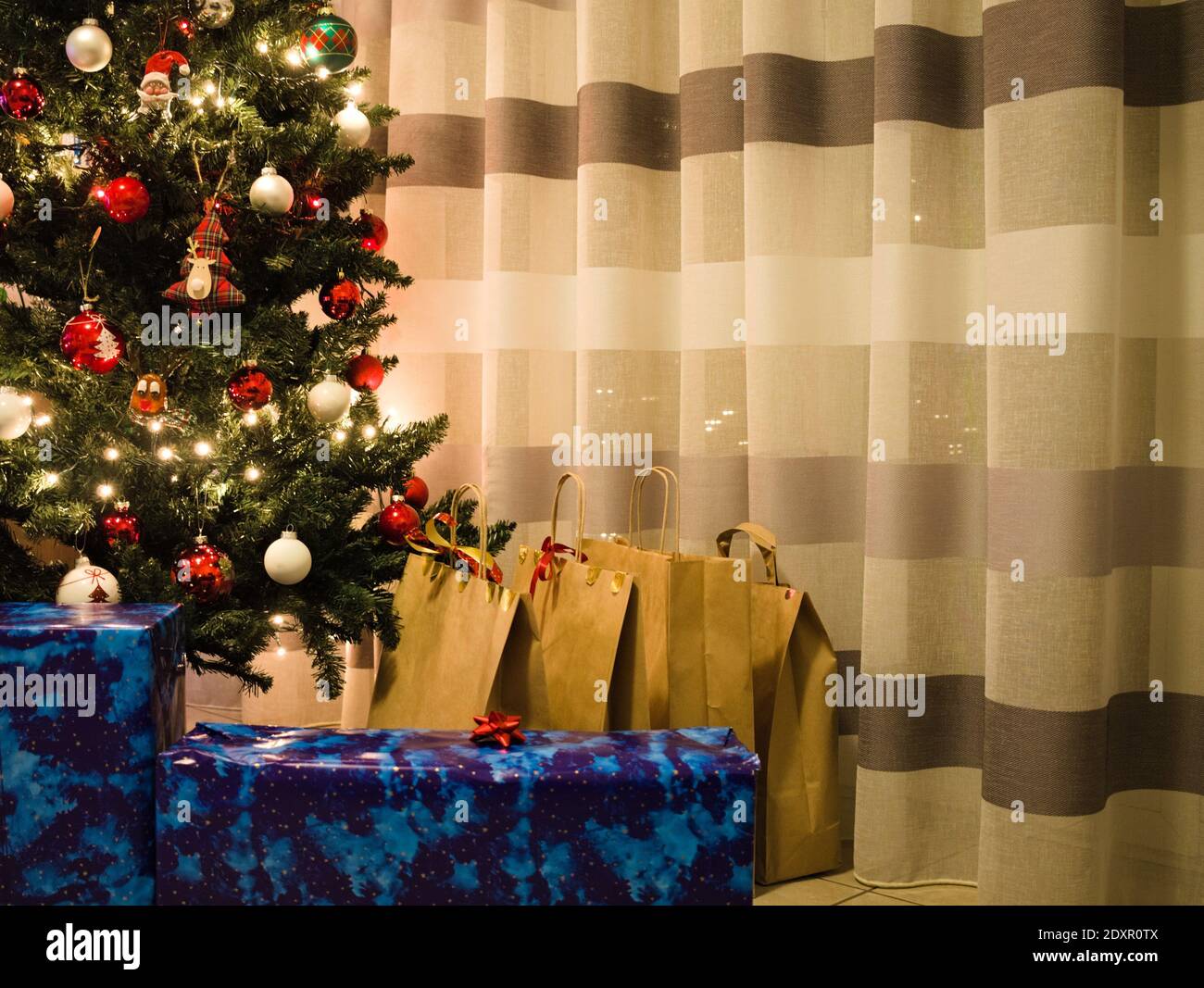 Weihnachtsgeschenke unter dem Weihnachtsbaum bei einem gestreiften Vorhang  (Marken, Italien, Europa Stockfotografie - Alamy