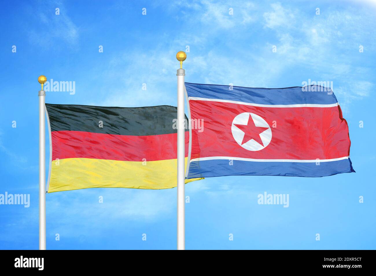 Deutschland und Nordkorea zwei Flaggen auf Fahnenmasten und blau wolkiger Himmel Stockfoto