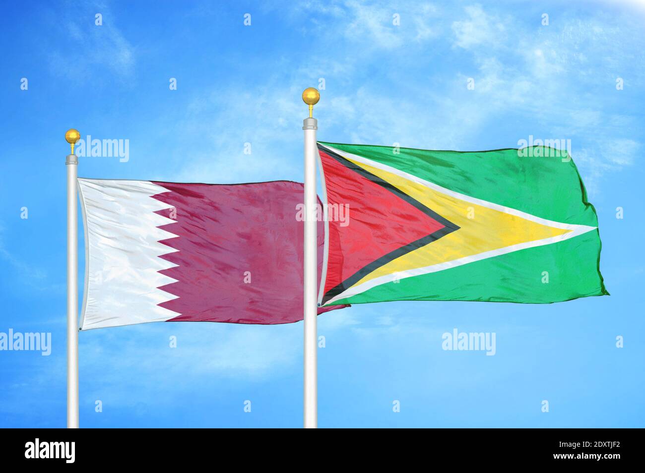 Katar und Guyana zwei Flaggen auf Fahnenmasten und blau bewölkt Himmel Stockfoto