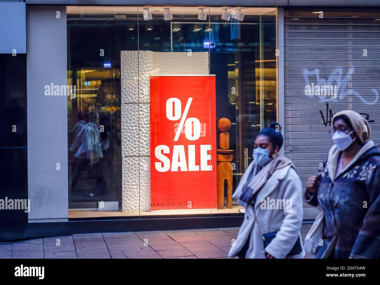 Essen, Ruhrgebiet, Nordrhein-Westfalen, Deutschland - Schaufenster eines Modehauses zur Weihnachtszeit mit Sonderangeboten, Passanten mit Schutzfolie Stockfoto