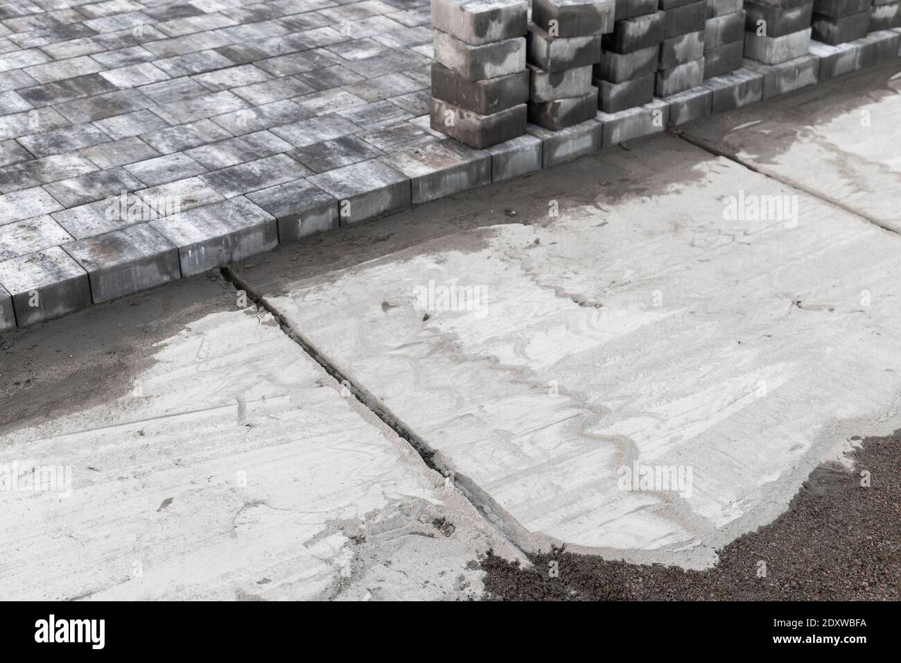 Verlegung von Pflasterplatten, Bodenausrichtung mit trockenem Zementsandgemisch, Hintergrundbild mit selektivem Fokus Stockfoto