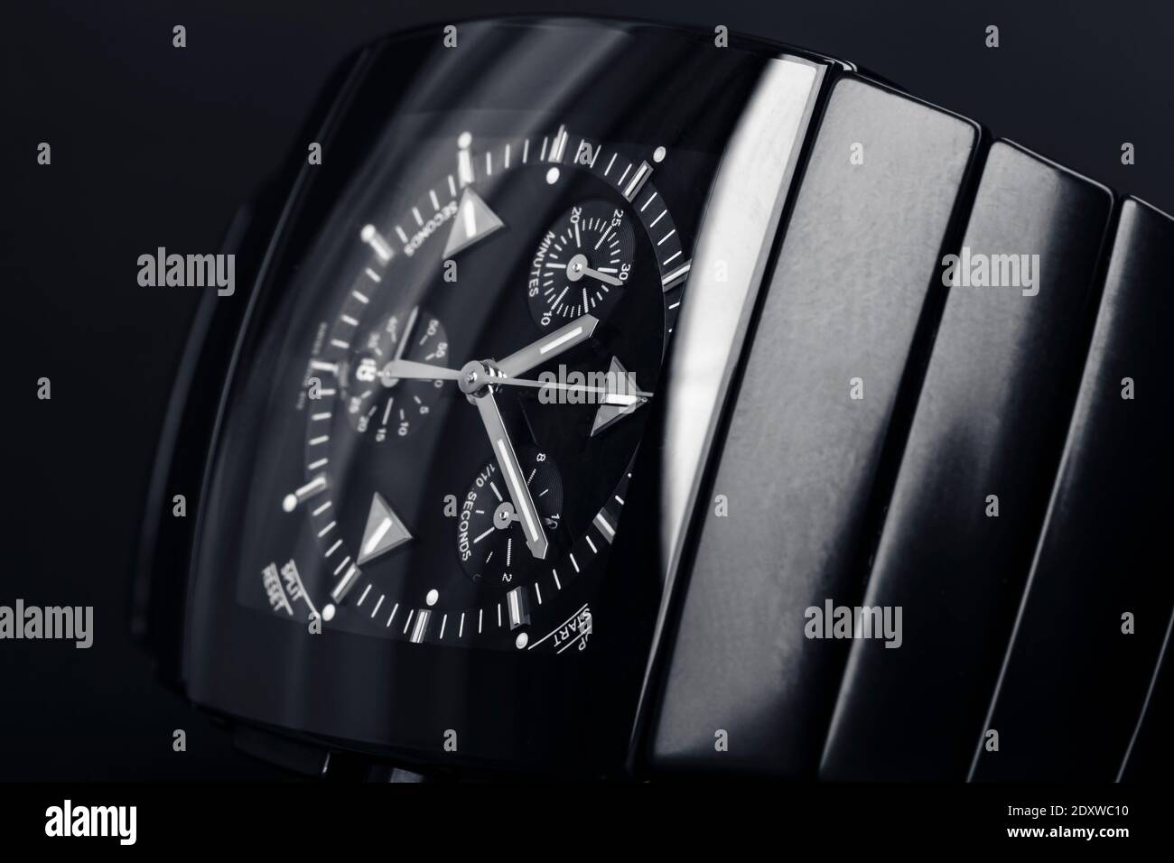Luxuriöse moderne Armbanduhr mit quadratischem Korpus aus schwarzer Keramik. Nahaufnahme mit selektivem Weichfokus Stockfoto