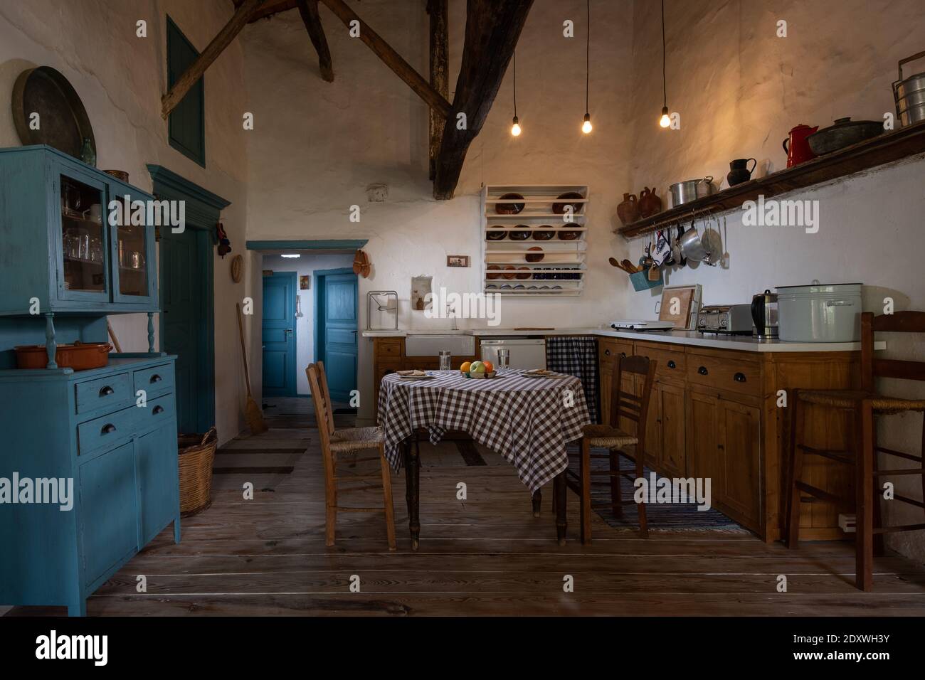 Traditionelles Interieur der alten Dorfküche im historischen Landhaus mit Stuckwänden, Holzbalken, Eichenholzmöbeln, Vintage-Geschirr Stockfoto