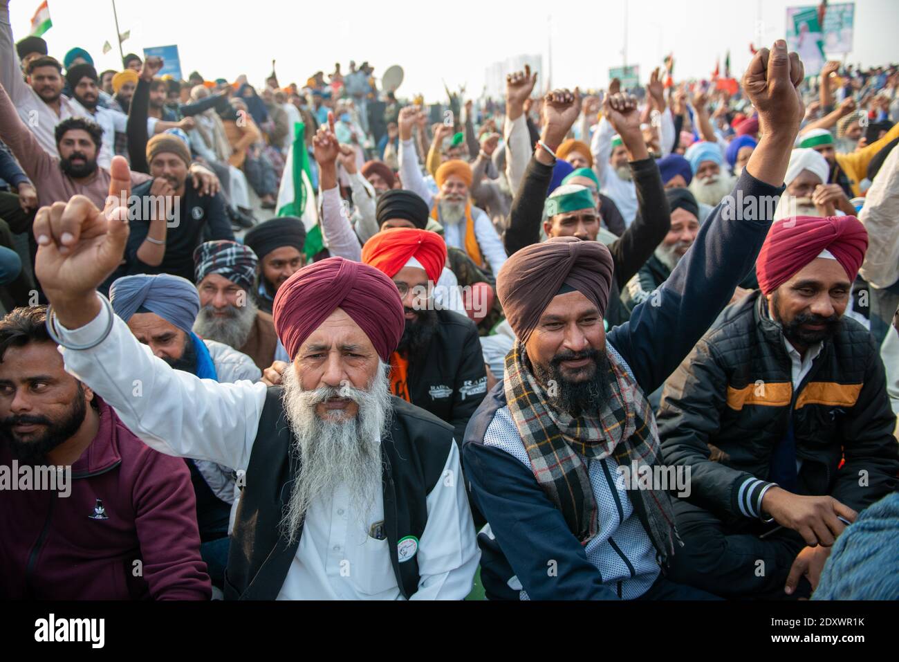 Demonstranten, die Slogans schreien, während sie auf dem Boden sitzen, während sie gegen die jüngsten Agrarreformen der Zentralregierung an der Grenze zu Ghazipur protestieren. Stockfoto