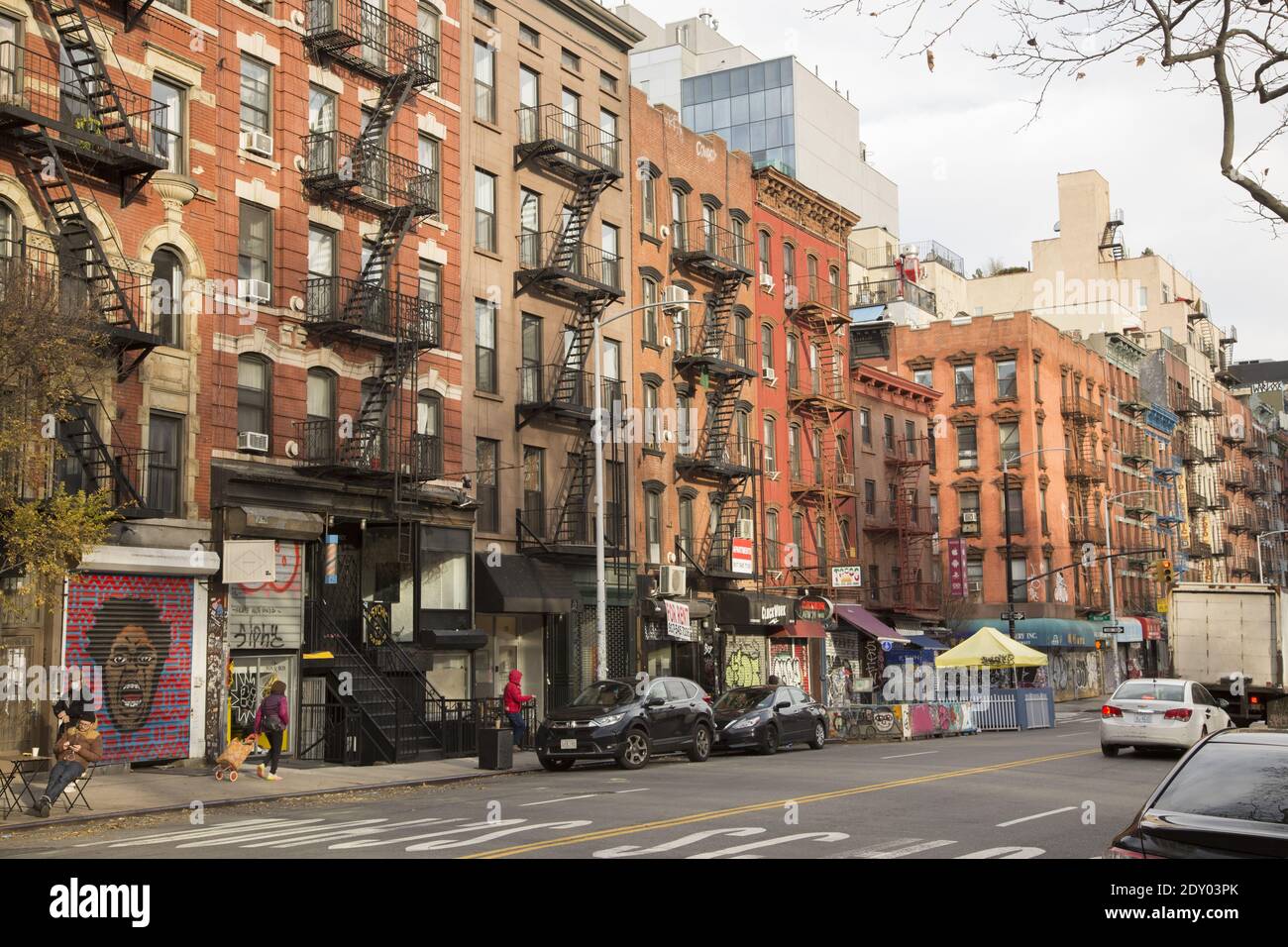 Clock Work Punkrock n Roll Bar zusammen mit anderen Geschäften in der Essex Street auf der Lower East Side von Manhattan. Alte Mietshaus wie Walkups mit Feuertreppen an der Vorderseite. Stockfoto