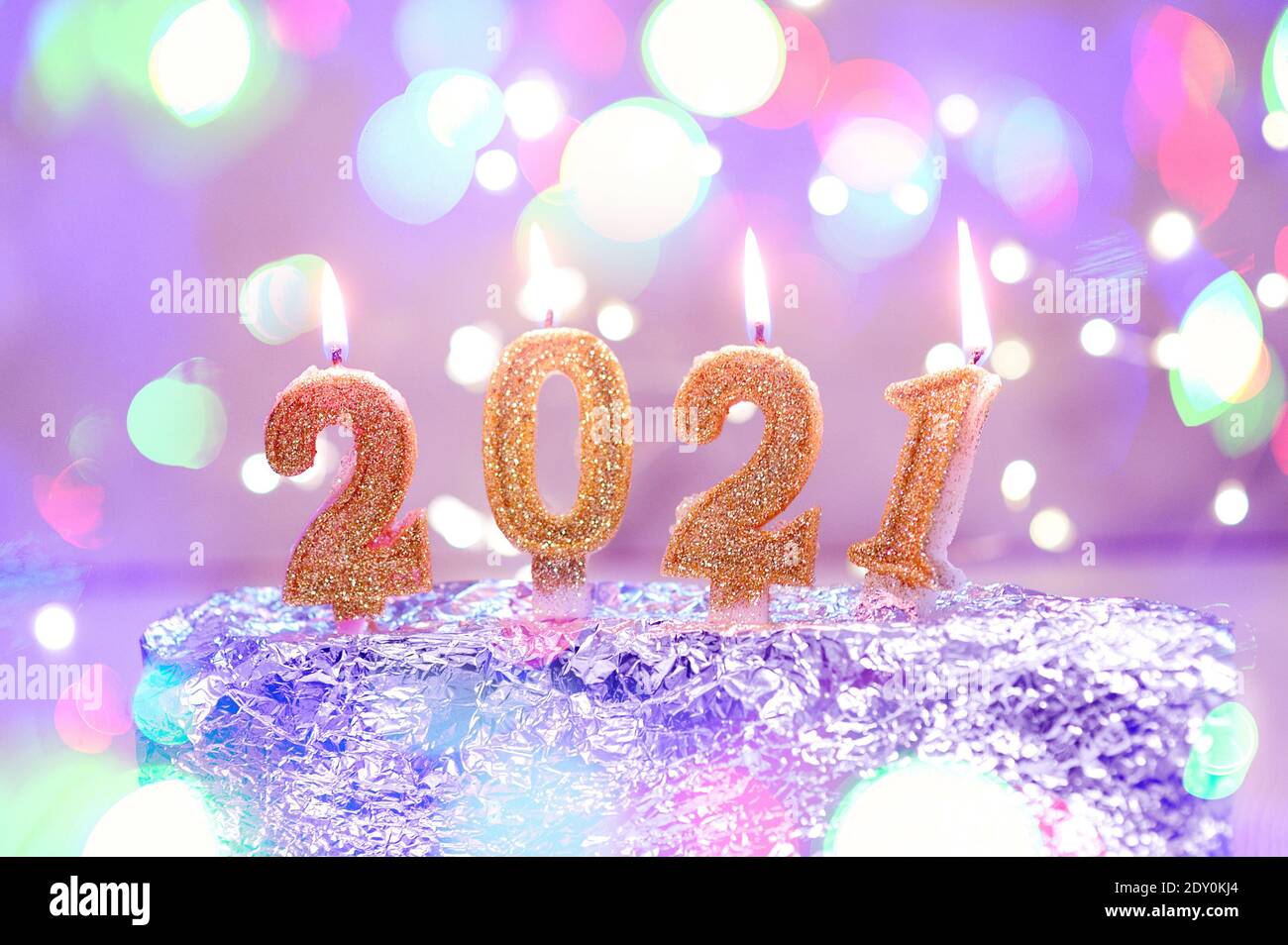 Urlaub Hintergrund Frohes neues Jahr 2021. Zahlen des Jahres 2021 von goldenen brennenden Kerzen auf Bokeh festlich funkelnden Hintergrund. Feiern Neujahr Stockfoto