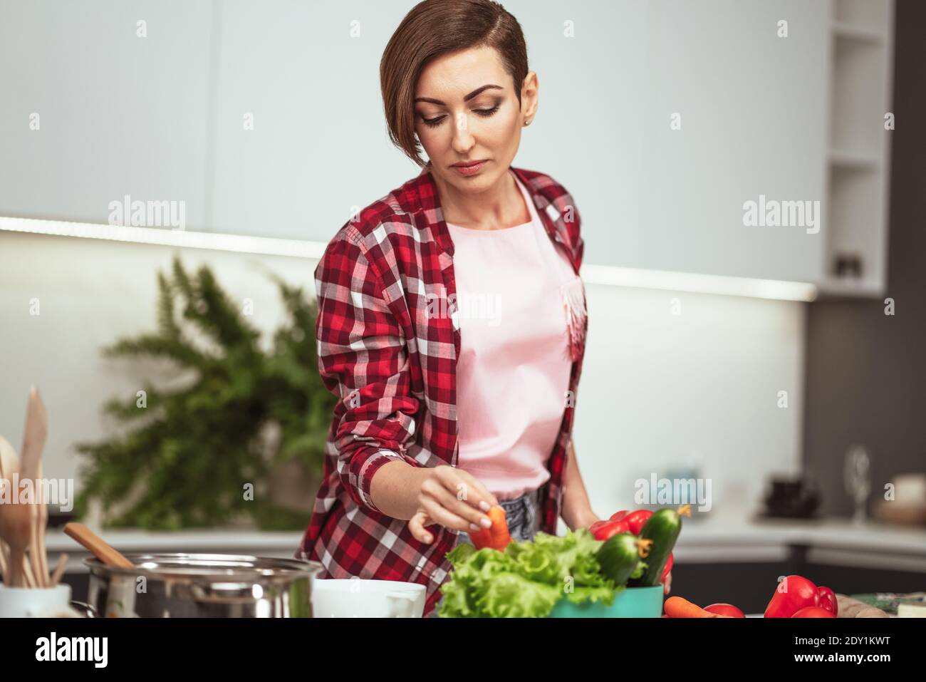 Kochen zu Hause für die liebevolle Familie. Zutaten auf dem Tisch vorbereiten junge Frau beim Kochen ein Mittagessen in der Küche stehend. Gesunde Ernährung leben. Gesund Stockfoto