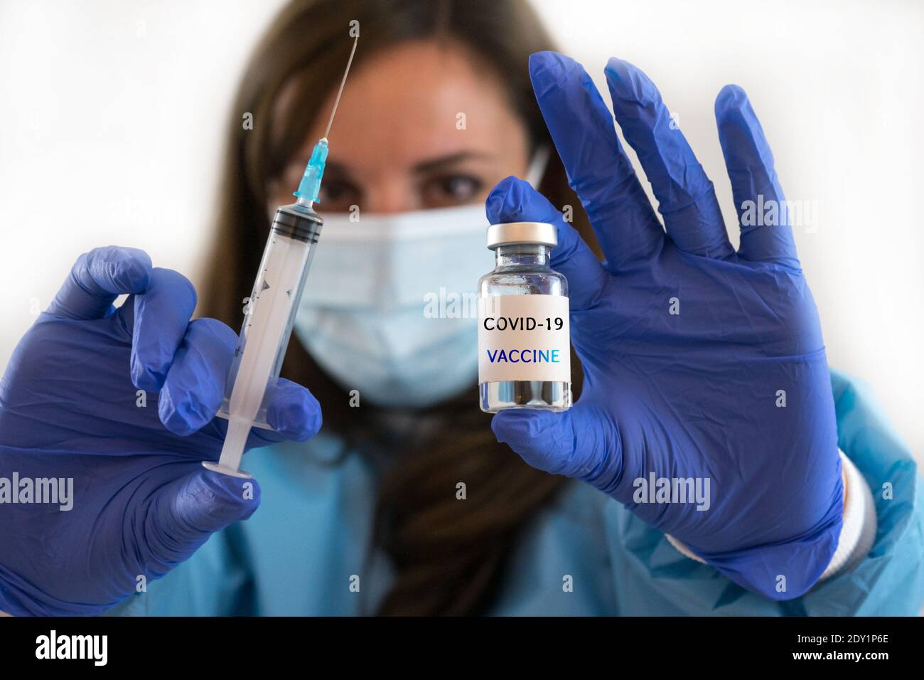 Kaukasische Frau Arzt oder Krankenschwester in Uniform und Handschuhe Tragen Gesichtsmaske Schutz in Labor halten Nadel Spritze Medikament Und Medizin Fläschchen Impfstoff bo Stockfoto