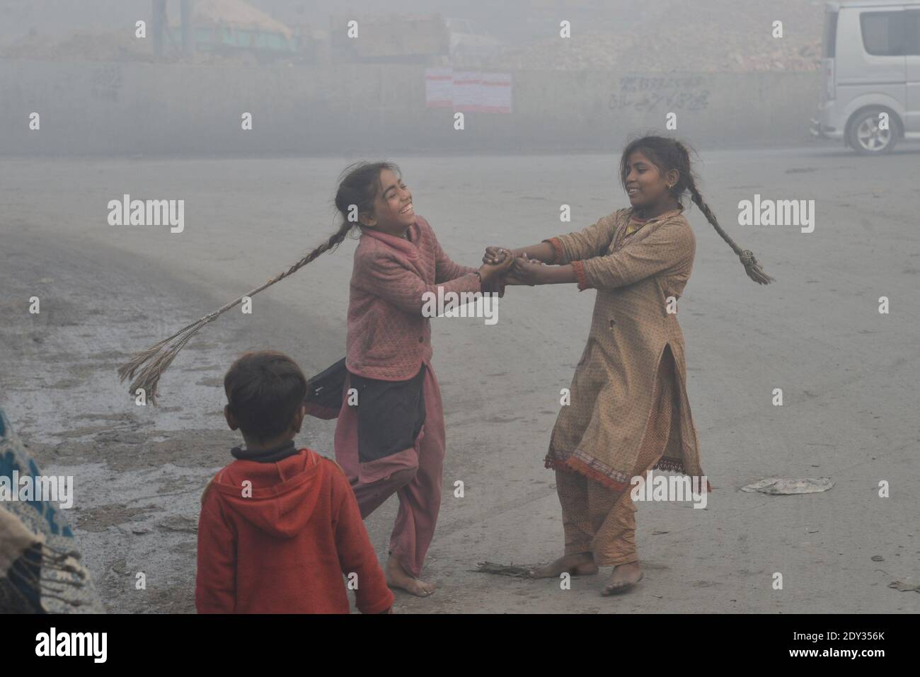 Pakistanische Pendler machen ihren Weg inmitten dichten Nebel auf ein Kalter Wintermorgen in Lahore Stockfoto