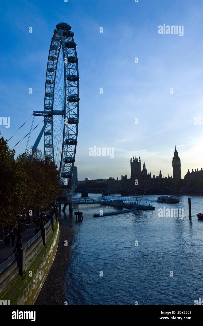 The Houses of Parliament und Big Beat Sonnenuntergang, hinter dem London Eye gesehen, ein riesiges Riesenrad am Südufer der Themse, London, England. Stockfoto