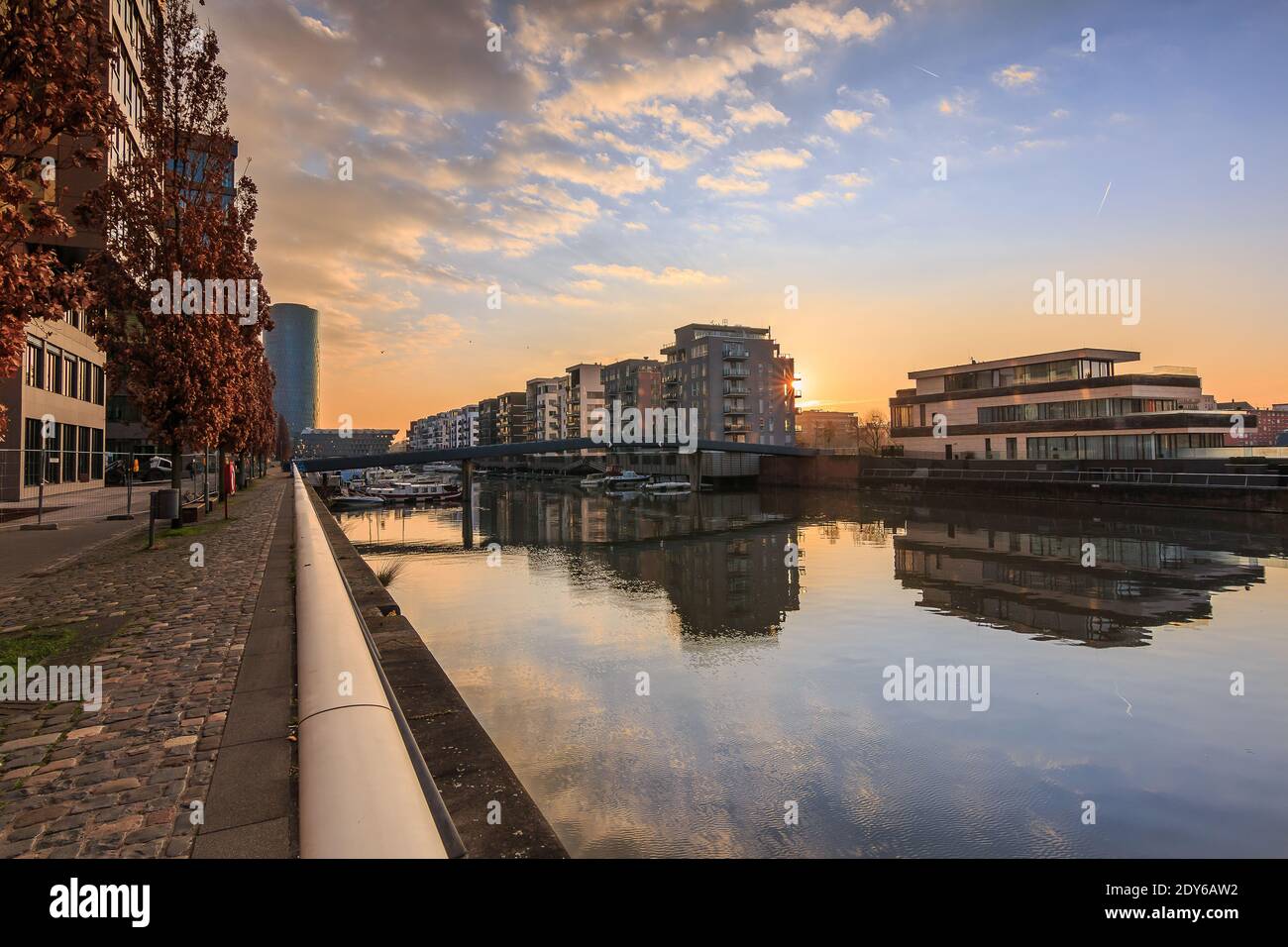 Kanal vom Main in Frankfurt. Wohngebiet am Morgen bei Sonnenaufgang. Wasserfront mit Reflexion. Blauer Himmel und Wolken. Ufer im por Stockfoto