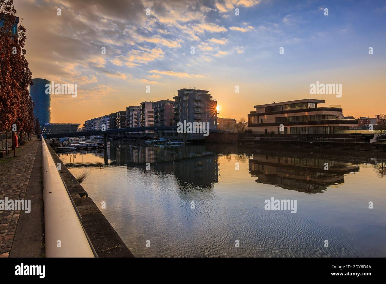 Wohngebiet am Main-Kanal in Frankfurt bei Sonnenaufgang. Wasserfront mit Reflexion. Blauer Himmel und Wolken.Ufer im Hafen und Gebäude Stockfoto