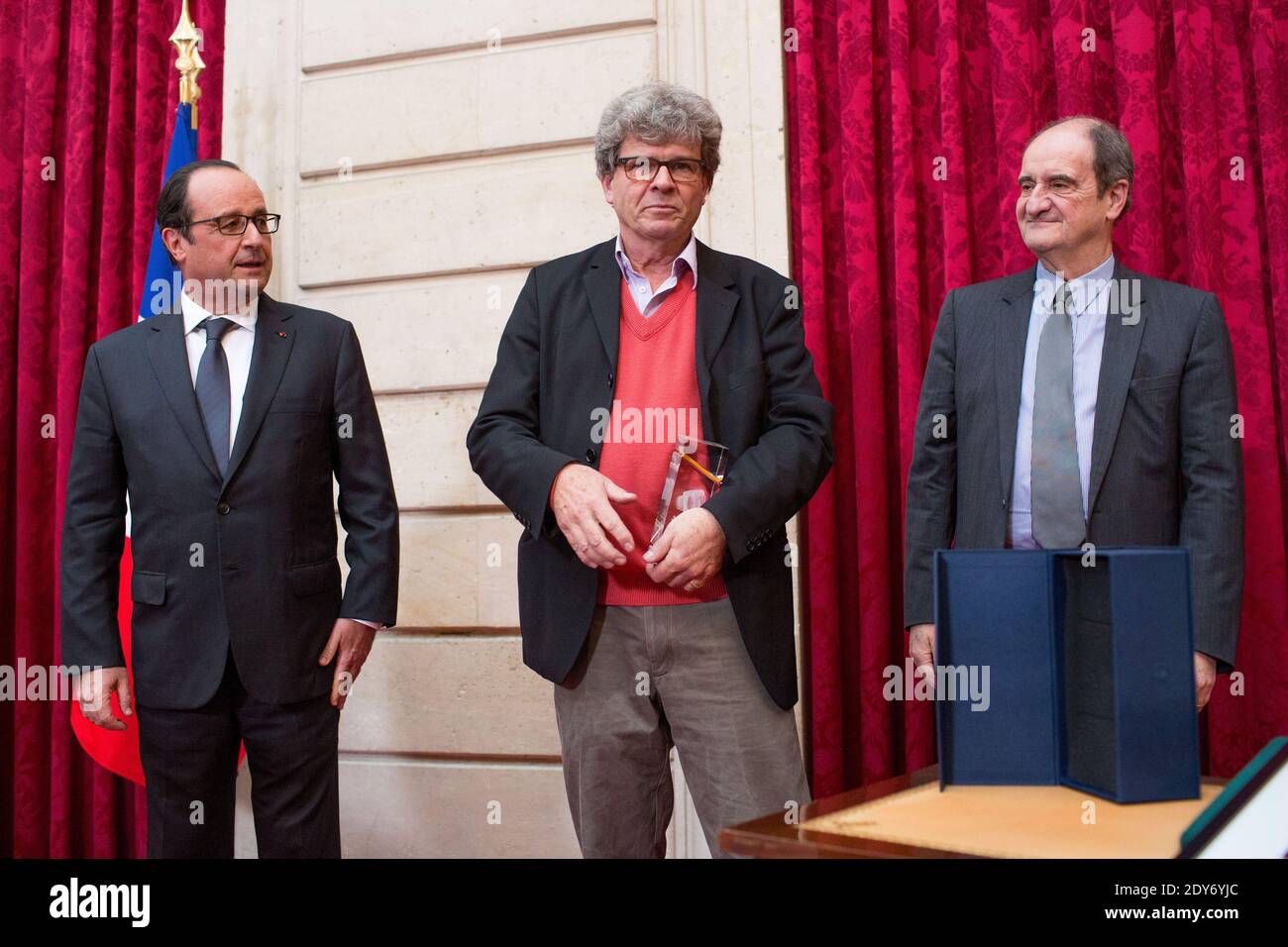 Der französische Präsident Francois Hollande (L) blickt auf Associated Press (AP) der Schweizer Fotograf Michel Euler (C), flankiert von dem französischen Journalisten und Vorsitzenden des Filmfestivals von Cannes Pierre Lescure (R), nachdem er am 2013 26. November 2014 den Elysee Photography Award im Elysee Palace in Paris, Frankreich, verliehen hatte. Fotopool von Revelli-Beaumont/ABACAPRESS.COM Stockfoto