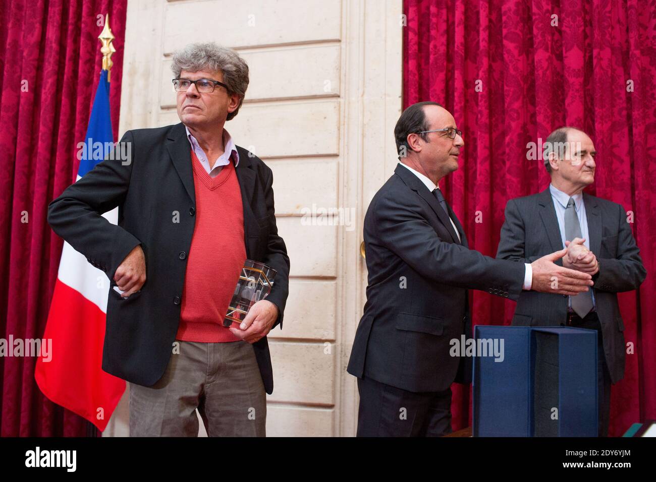 Associated Press (AP) der Schweizer Fotograf Michel Euler (L) hält seine Trophäe, nachdem er am 26. November 2014 vom französischen Präsidenten Francois Hollande (C) und dem französischen Journalisten und Vorsitzenden des Filmfestivals von Cannes Pierre Lescure (R) des Elysee Photography Awards 2013 im Elysee Palace in Paris, Frankreich, ausgezeichnet wurde. Fotopool von Revelli-Beaumont/ABACAPRESS.COM Stockfoto