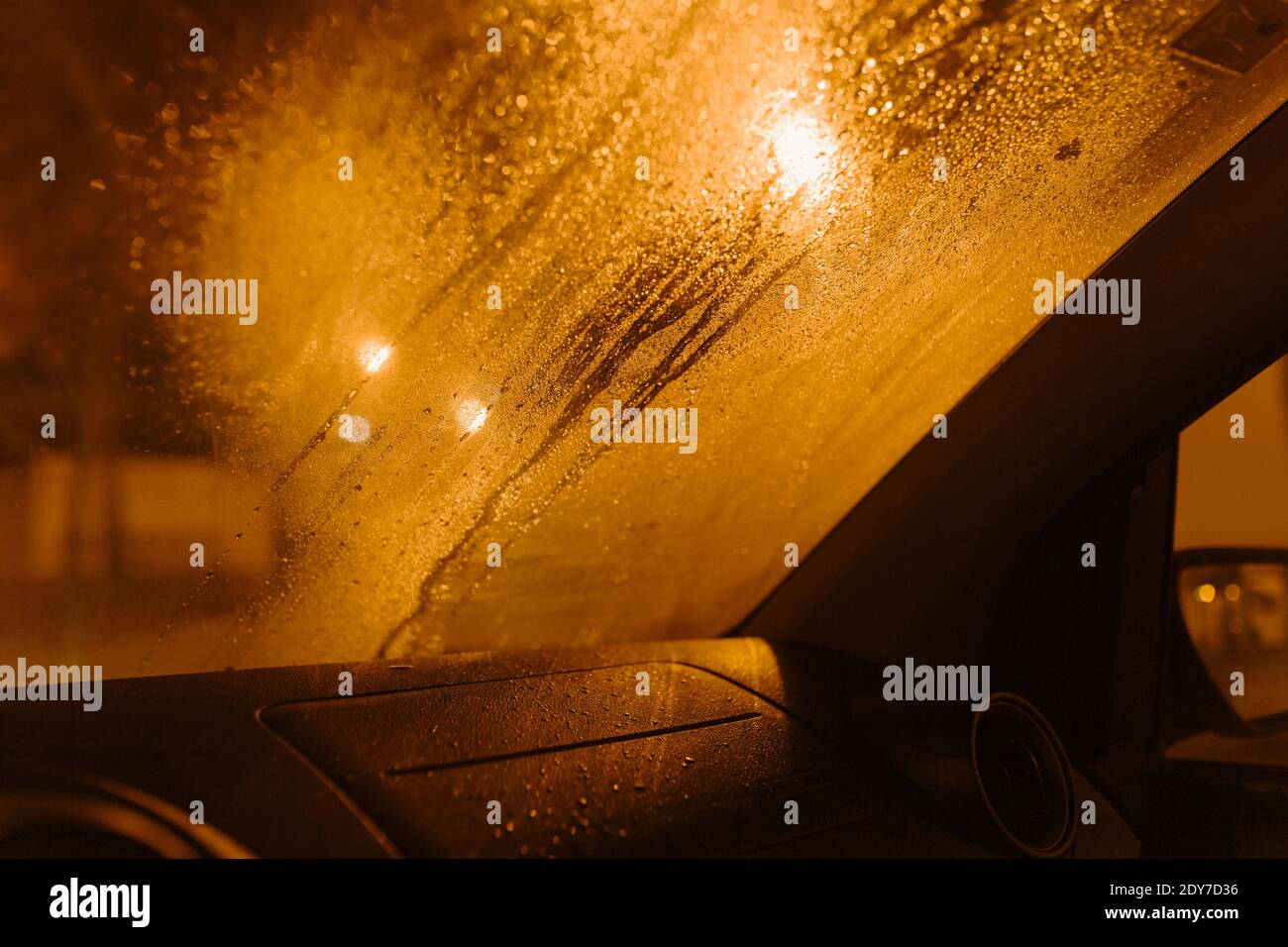 Regen fällt in einem regnerischen Tag auf Schaufensterwagen mit Lampe Straße. Tautropfen. Stockfoto