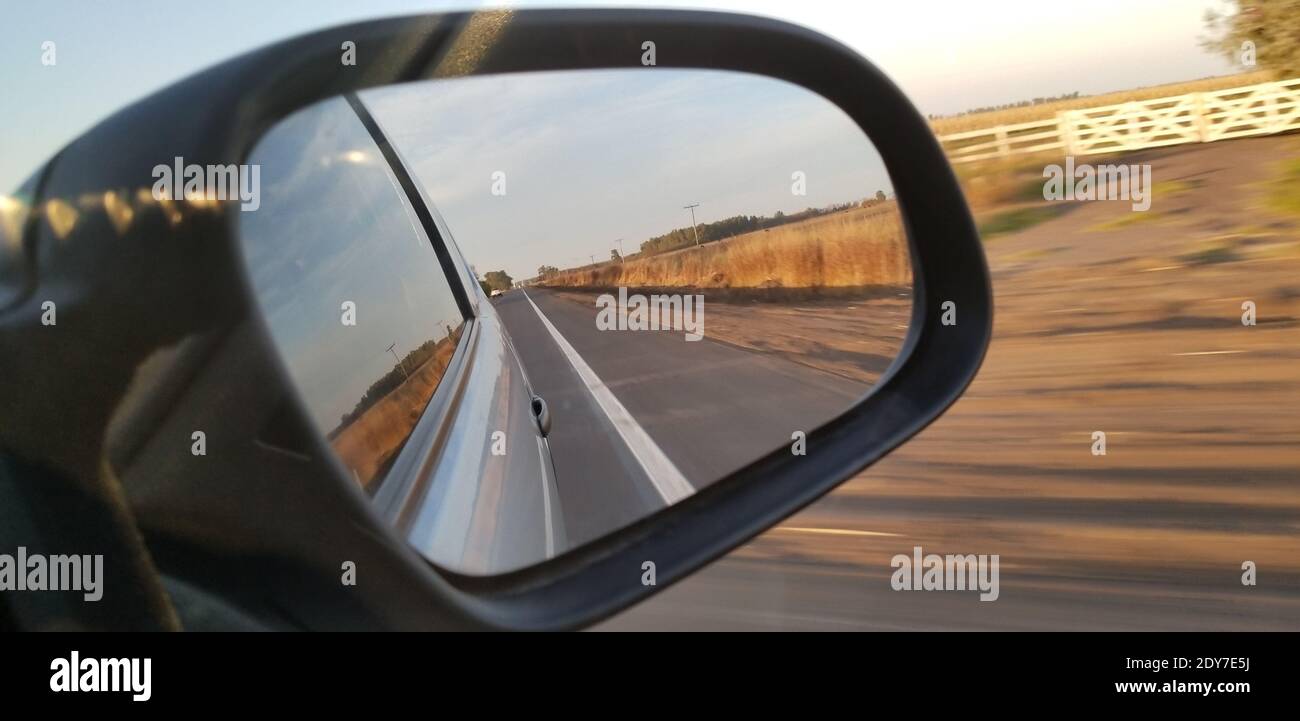 Spiegelung von Himmel und Straße im Seitenspiegel Stockfoto