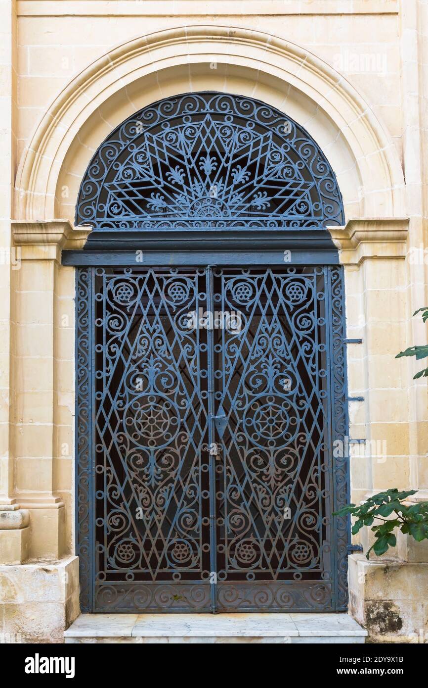 Gewölbte Eingangstür mit verzierten schmiedeeisernen Grills, Garten des Grand Masters Palace, Valletta, Malta Stockfoto