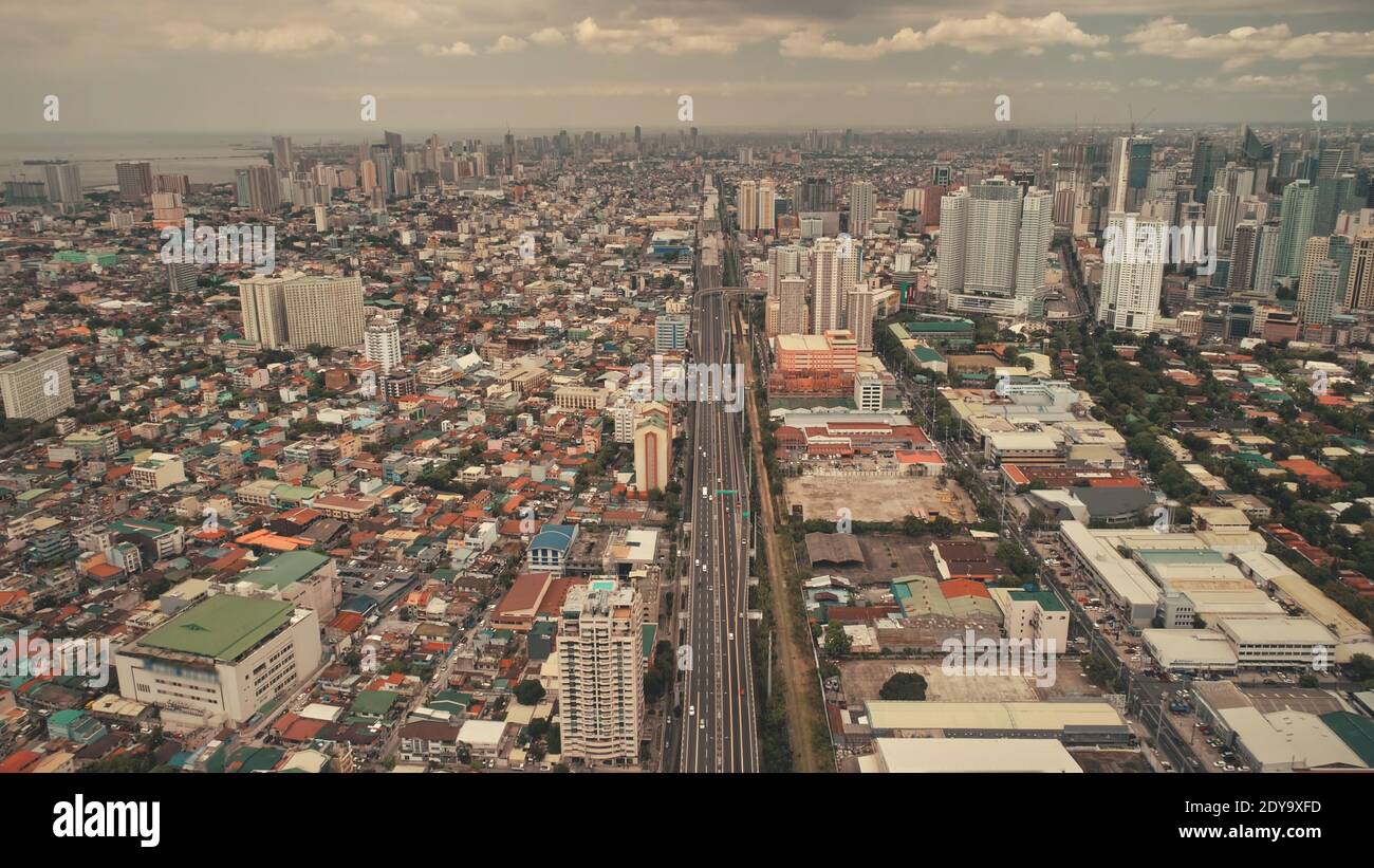 Top-down-Parkplatz an hohen Gebäuden, Autobahn mit Autos und Lastwagen. Downtown Verkehrsstraße bei Stadtbild Stadtlandschaft in Luftaufnahme. Nahverkehr der philippinischen Hauptstadt Manila Stadt Drohne erschossen Stockfoto