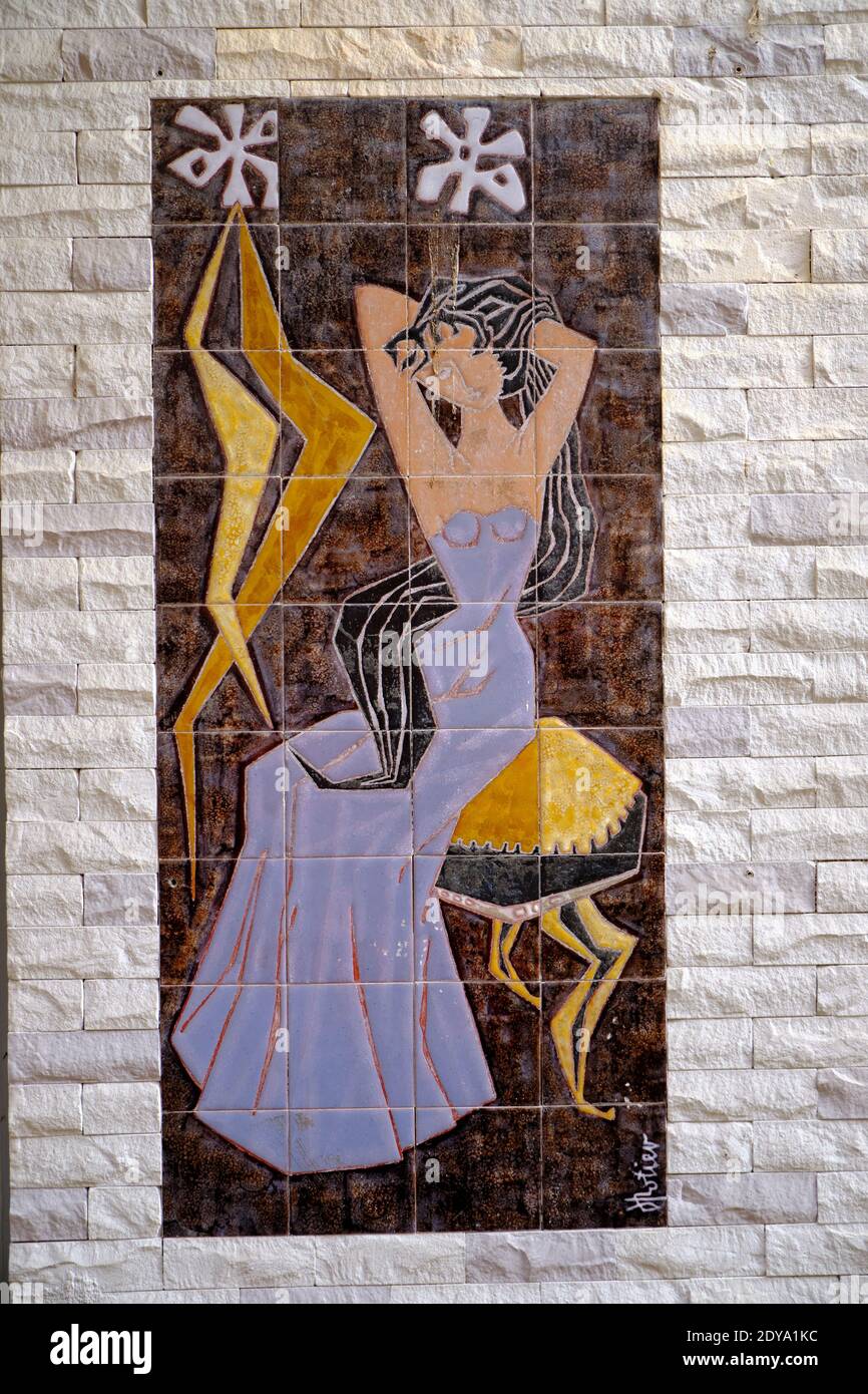 Wandkunst aus Keramikfliesen in einem Gebäude mit Frauen im Abendkleid in Frankreich Stockfoto