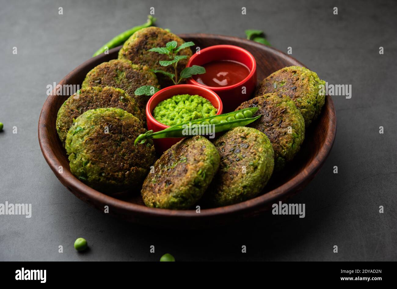 Hara bhara Kabab oder Kebab ist indische vegetarische Snack-Rezept mit grünen Minze Chutney über launischen Hintergrund serviert. Selektiver Fokus Stockfoto