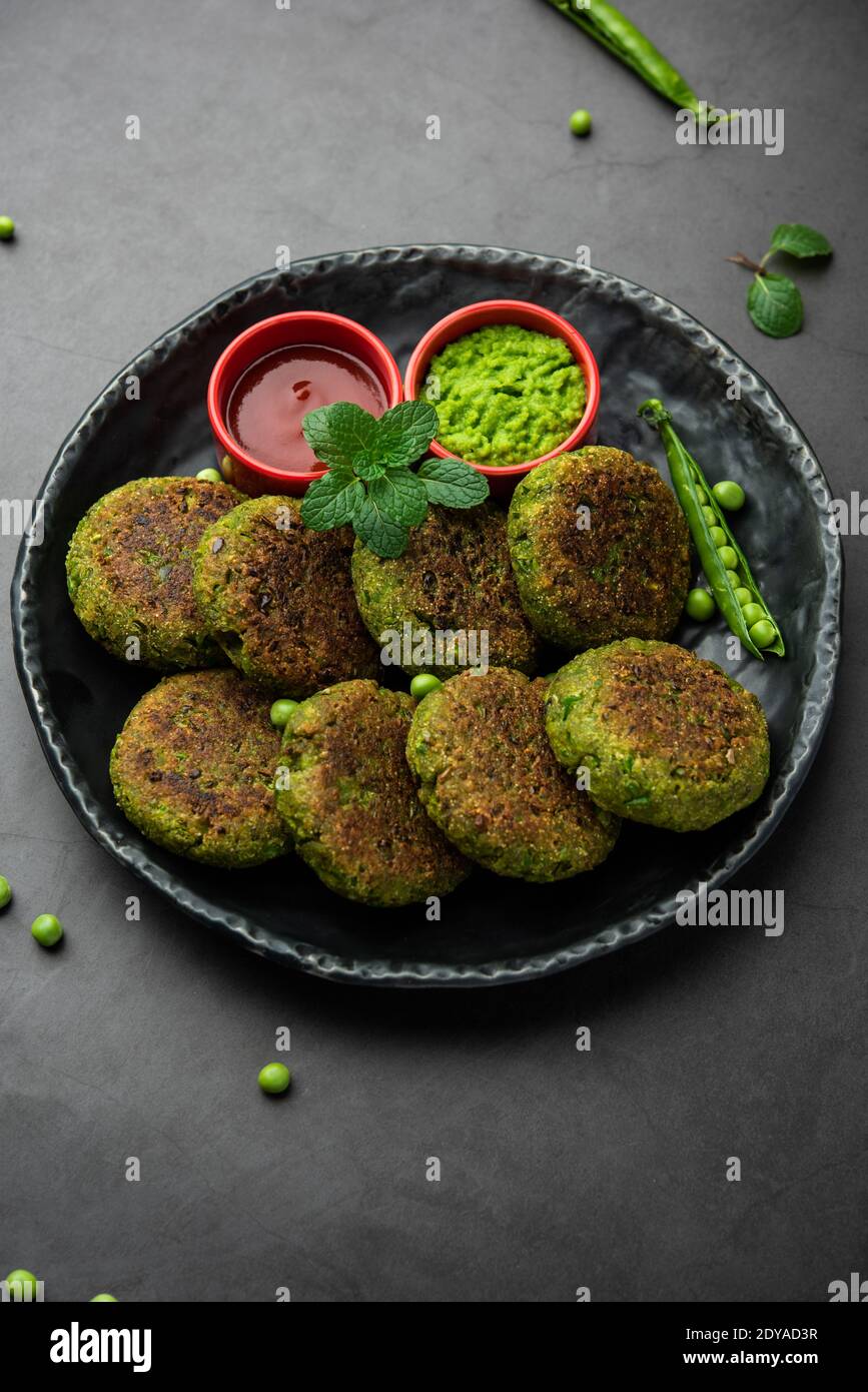 Hara bhara Kabab oder Kebab ist indische vegetarische Snack-Rezept mit grünen Minze Chutney über launischen Hintergrund serviert. Selektiver Fokus Stockfoto