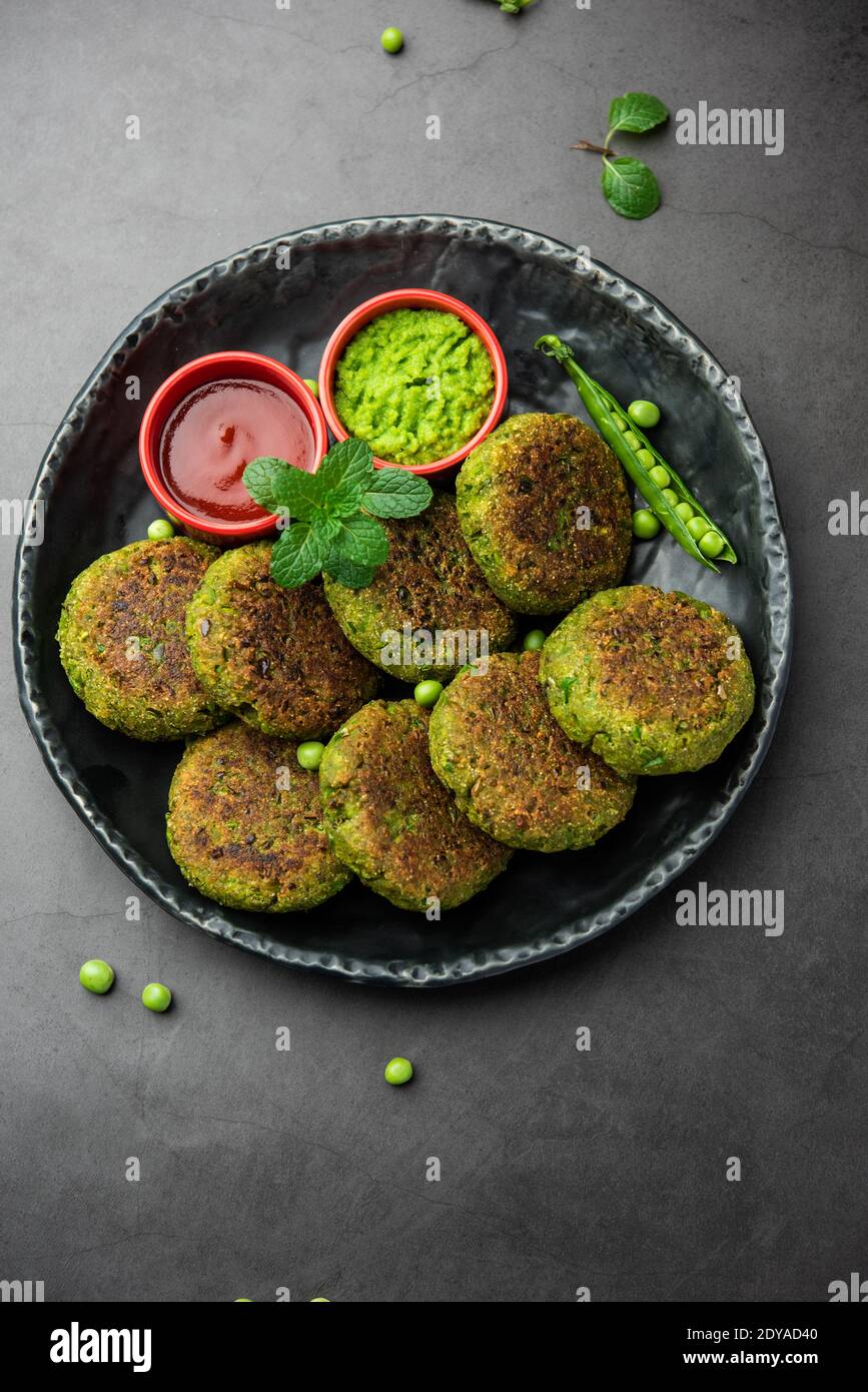 Hara bhara Kabab oder Kebab ist indische vegetarische Snack-Rezept mit grünen Minze Chutney über launischen Hintergrund serviert. Selektiver Fokus Stockfoto