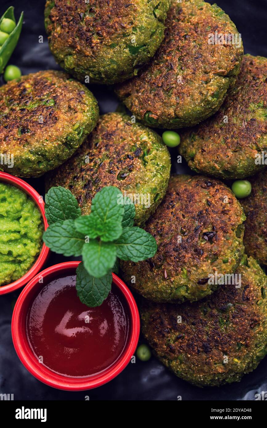 Hara bhara Kabab oder Kebab ist indische vegetarische Snack-Rezept mit grünen Minze Chutney über launischen Hintergrund serviert. Selektiver Fokus Stockfoto