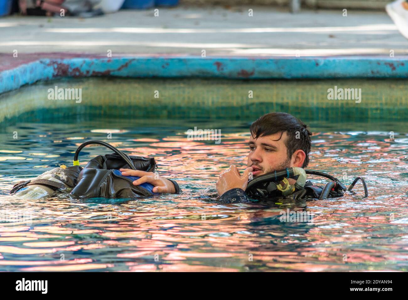 diver ohne seine Stacheln hilft einem anderen ins Wasser zu tauchen Stockfoto