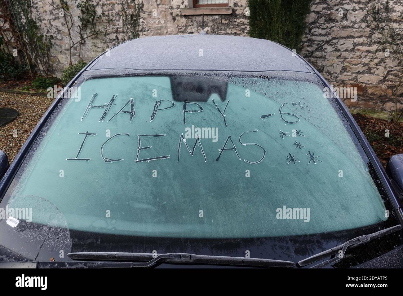 Garstang, Lancashire, 25. Dezember 2020. Eine Windschutzscheibe, auf der die Worte „Happy Icemas -6 Grad“ in Eis eingeätzt wurden, als am Weihnachtstag im Jahr 2020 Temperaturen unter Null in Nordengland herrschten. Temperaturen von minus 6 fror Garstang in Lancashire bis zum Kern ein. Eine frostige Decke mit Autos und Windschutzscheiben. Quelle: Stop Press Media/Alamy Live News Stockfoto