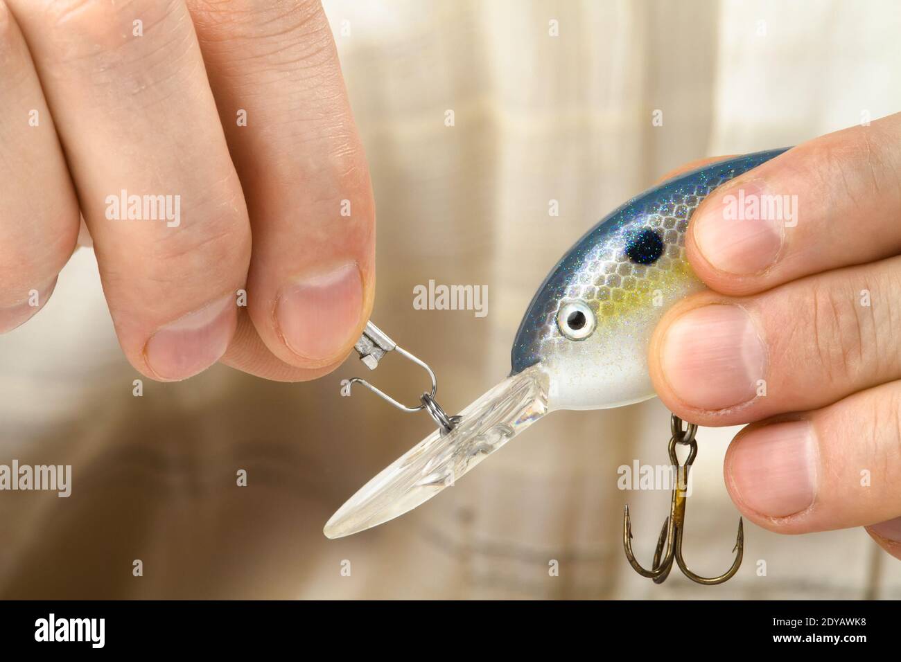 Angler befestigt den Kunststoff-Wobbler an der Draht Angelschnur, Nahaufnahme Stockfoto