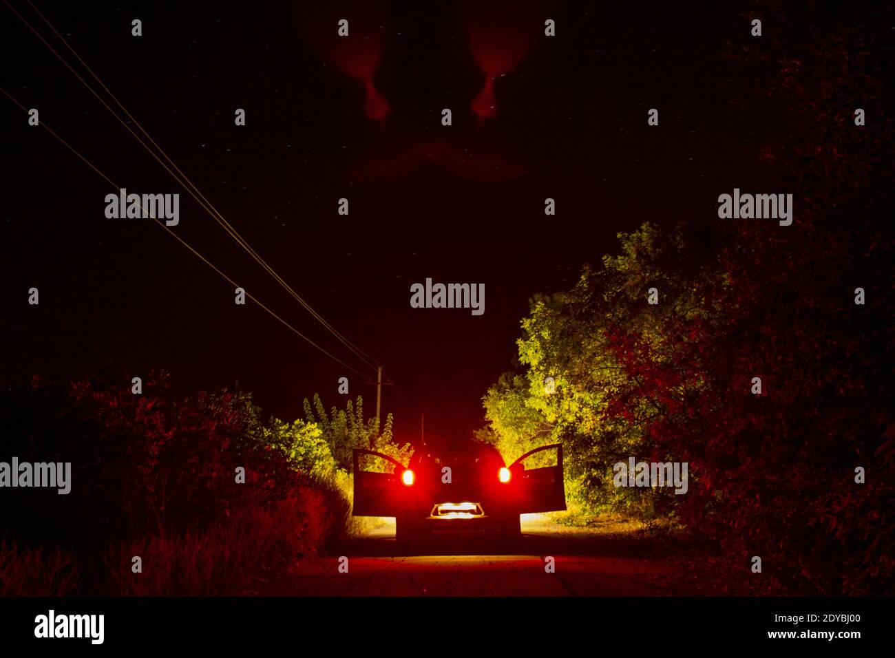 Auto auf der Straße mit roten Scheinwerfern und offenen Türen. Hochwertige Fotos Stockfoto