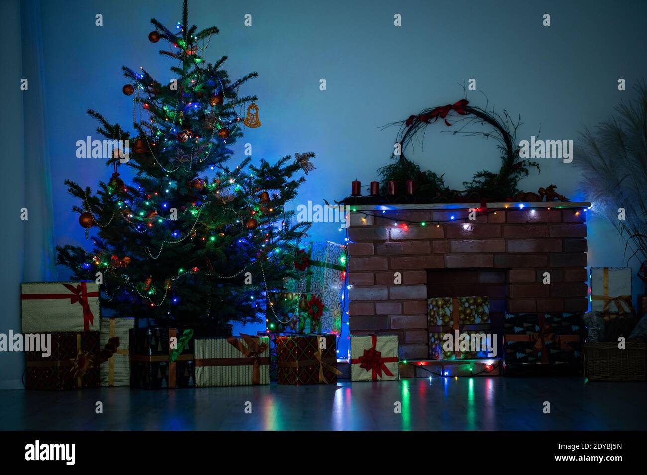 Glänzende Weihnachtsbaumlichter. Dämmerung im Wohnzimmer zu Hause. Dekoration für Weihnachten. Stockfoto