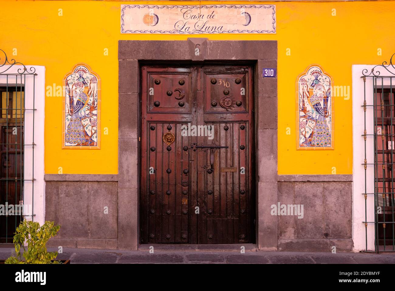 Tür der Casa de La Luna, mit typisch mexikanischer Kunst auf beiden Seiten, in ruhiger Puebla Straße Stockfoto