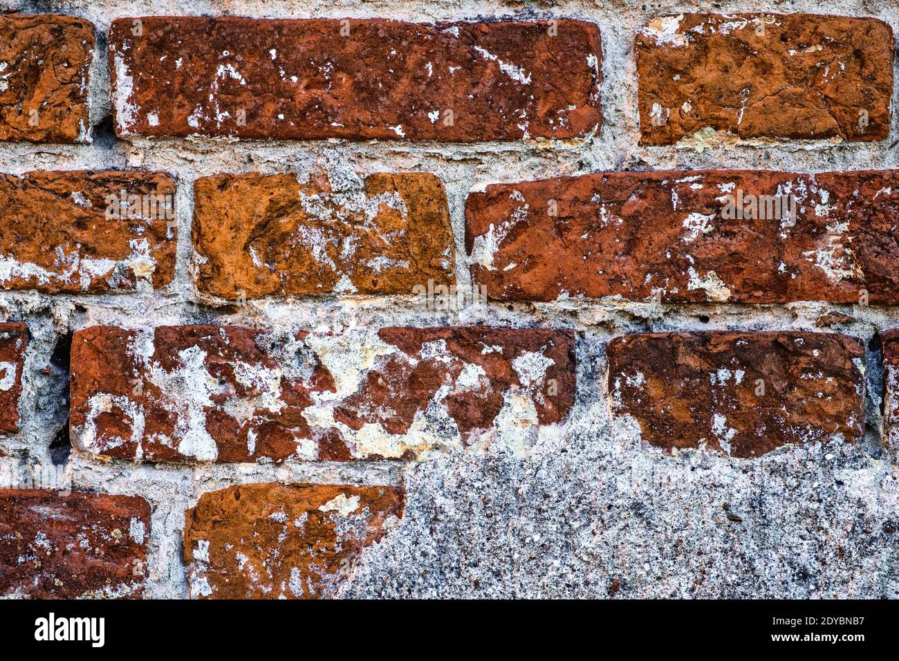 Antikes Mauerwerk mit Rissen und Gips-Nahaufnahme Stockfoto