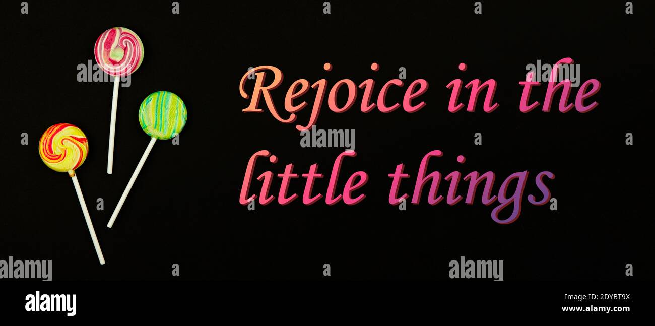 Motivations-Slogan, Freude in den kleinen Dingen, Lutscher auf schwarzem Hintergrund, Ruhe nach einem harten emotionalen Tag, kopieren Raum Banner Foto Stockfoto