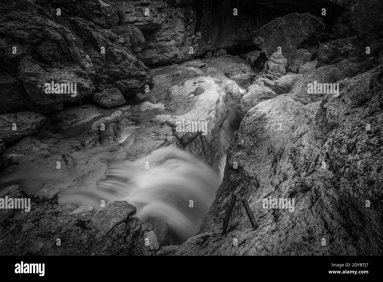 Kleine Wasserfälle von transparentem Wasser in einer felsigen Schlucht. Schwarzweiß-Foto Stockfoto