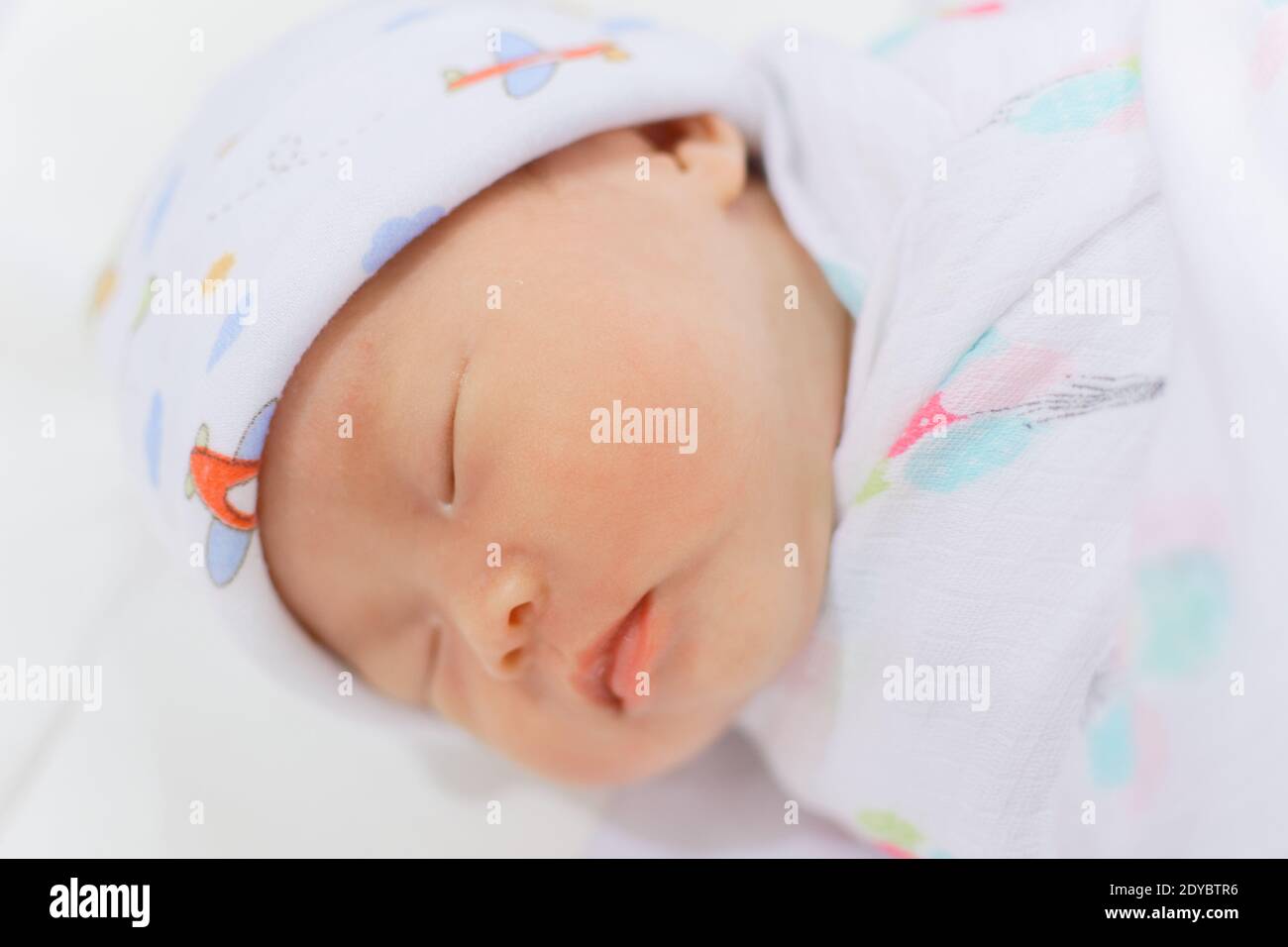 Neugeborenes chinesisches Baby Mädchen weniger als einen Monat alt schlafen solide, warm in Musselin Tuch eingewickelt. Stockfoto
